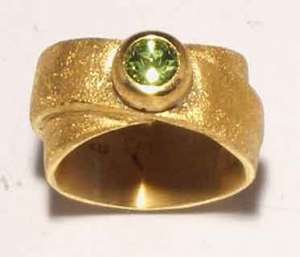 Breiter goldplattierter Ring mit einem Peridot.