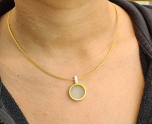 Schlichter Anhänger mit einem weißen Achatkristall und goldenem Rändchen.