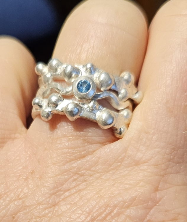 Doppelter Kugelring mit Wellenring und einem Topas